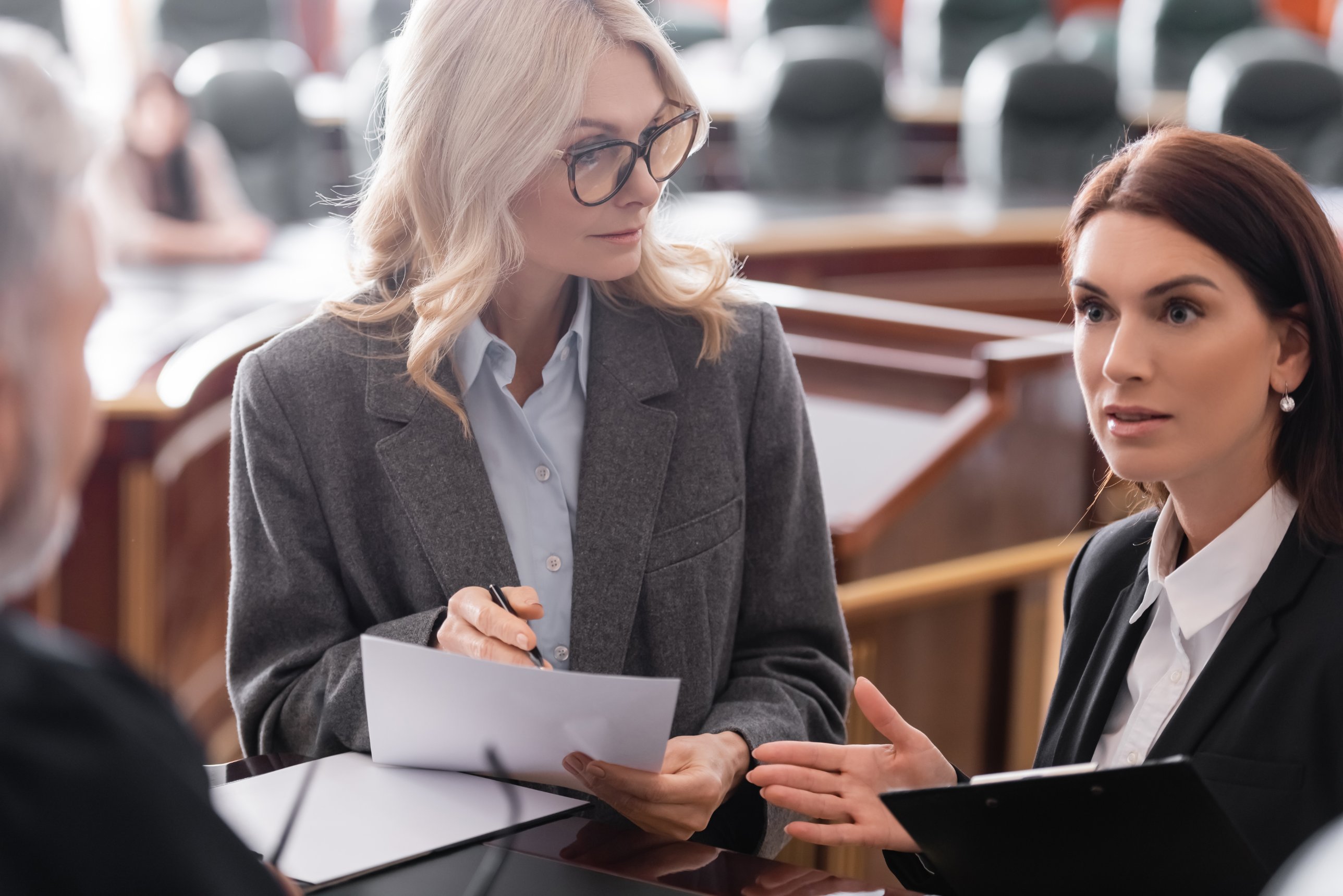 Two lawyers discussing documents in a courtroom